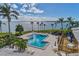 Aerial view of a community pool surrounded by palm trees, with views of the bay at 11000 Placida Rd # 702, Placida, FL 33946