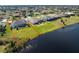 Aerial view of the property with a screened pool, lush lawn, and water view at 12 Sportsman Ter, Rotonda West, FL 33947