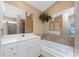Bathroom featuring tiled floor, walk-in shower, soaking tub, and lots of counter space at 12 Sportsman Ter, Rotonda West, FL 33947