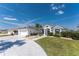 A beautifully landscaped home exterior with a white driveway and lush, green lawn at 12 Sportsman Ter, Rotonda West, FL 33947