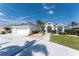 A beautifully landscaped home exterior with a white driveway and lush, green lawn at 12 Sportsman Ter, Rotonda West, FL 33947
