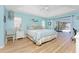 Bright bedroom with aqua colored walls, wood floors, ceiling fan, and access to the lanai at 12 Sportsman Ter, Rotonda West, FL 33947