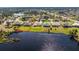 Aerial of the rear exterior featuring an in-ground screened-in pool with a view of the bordering lake at 12 Sportsman Ter, Rotonda West, FL 33947