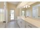Well-lit bathroom featuring long vanity with a large mirror, and a doorway to a private water closet at 127 White Marsh Ln, Rotonda West, FL 33947