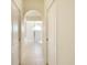 Bright bathroom hallway featuring tile flooring and arched doorway to a shower with semi-circular glass detail at 127 White Marsh Ln, Rotonda West, FL 33947