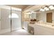 Bright bathroom featuring white cabinets, dual sinks, and a shower at 127 White Marsh Ln, Rotonda West, FL 33947
