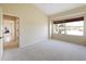Large bedroom featuring neutral carpet, a window view, and a connecting hall for easy access to other areas at 127 White Marsh Ln, Rotonda West, FL 33947