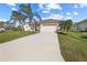 Charming single Gathering home boasts a spacious driveway and a well-maintained lawn with mature palm trees at 127 White Marsh Ln, Rotonda West, FL 33947