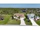 An aerial view displays a home with palm trees, a lush lawn, and a long driveway at 127 White Marsh Ln, Rotonda West, FL 33947