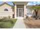 Close-up of the home's charming front porch with decorative door and beautiful landscaping at 127 White Marsh Ln, Rotonda West, FL 33947