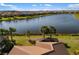 Backyard with a lake view and a screened lanai area; aerial perspective from above the roof at 13137 Oriago St, Venice, FL 34293