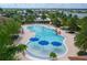 Large community pool with beach entry, fountains, and ample seating under umbrellas and palm trees at 13137 Oriago St, Venice, FL 34293