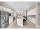 Open floor plan showing the kitchen with an island and stainless appliances, connected to dining and living areas at 13137 Oriago St, Venice, FL 34293