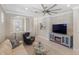 Bright living room with a fan and modern TV console, with a peek into the entryway at 13137 Oriago St, Venice, FL 34293