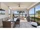Covered patio features a dining area, a lounge area, and an outdoor grill overlooking the lake at 13137 Oriago St, Venice, FL 34293