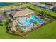 Aerial view of community pool featuring lounge chairs, palm trees, and shaded areas at 13137 Oriago St, Venice, FL 34293