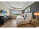 Bright main bedroom featuring tray ceiling, wood floors, and stylish decor at 1409 Remington Trace Dr, Port Charlotte, FL 33953