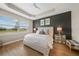 Serene main bedroom featuring a tray ceiling, a large window, and a neutral color palette for a tranquil retreat at 1409 Remington Trace Dr, Port Charlotte, FL 33953