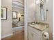 Stylish powder room with a granite vanity, decorative lighting, and an archway entrance to the hallway at 1409 Remington Trace Dr, Port Charlotte, FL 33953