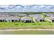 Back view of homes, showcasing the well-maintained lawns and lake views, under a partly cloudy sky at 1409 Remington Trace Dr, Port Charlotte, FL 33953