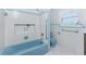 Retro blue tiled bathroom with tub, shower, and white flooring needs remodel at 1456 Deer Creek Dr, Englewood, FL 34223