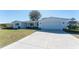 Single-story home with a two-car garage, well-kept lawn, and mature landscaping at 1456 Deer Creek Dr, Englewood, FL 34223