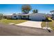Single-story home with a two-car garage, well-kept lawn, and mature landscaping at 1456 Deer Creek Dr, Englewood, FL 34223