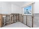 Laundry room with white cabinets, tile floors, and a window overlooking the outdoors at 1456 Deer Creek Dr, Englewood, FL 34223