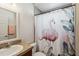 This bathroom offers a decorative flamingo themed shower curtain and a vanity with a sink at 15578 Seafoam Cir, Port Charlotte, FL 33981
