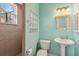 Bright bathroom with pedestal sink, decorative mirror and glass block window by shower at 15578 Seafoam Cir, Port Charlotte, FL 33981