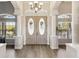 Elegant home entrance featuring double doors, soaring ceilings, and stylish flooring and architectural columns at 15578 Seafoam Cir, Port Charlotte, FL 33981