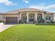 Beautiful single-story home featuring a lush green lawn, double-door entrance, and an attached two-car garage at 15578 Seafoam Cir, Port Charlotte, FL 33981