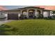 Charming single-story home featuring a well-manicured lawn and inviting front entrance with decorative pillars at 15578 Seafoam Cir, Port Charlotte, FL 33981