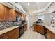 Bright kitchen featuring wood cabinetry, black appliances, granite countertops, and tiled backsplash at 15578 Seafoam Cir, Port Charlotte, FL 33981