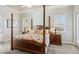 Bright and airy main bedroom with a four-poster bed, side tables, and natural light from two windows at 15578 Seafoam Cir, Port Charlotte, FL 33981