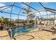 Private pool area with screened enclosure, sun loungers, and tranquil waterfront views, ideal for outdoor relaxation at 15578 Seafoam Cir, Port Charlotte, FL 33981