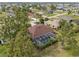 Aerial view of a house with a screened-in pool surrounded by trees, showcasing the backyard and neighborhood at 16137 Alcira Cir, Punta Gorda, FL 33955