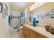 Clean bathroom with a bathtub, large mirror, and white tile flooring at 16137 Alcira Cir, Punta Gorda, FL 33955