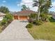 Well-maintained home with mature landscaping, a paver driveway, and a spacious two-car garage at 16137 Alcira Cir, Punta Gorda, FL 33955