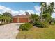 Inviting single-story home boasts a brick paved driveway, mature palms, and verdant landscaping at 16137 Alcira Cir, Punta Gorda, FL 33955