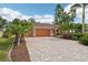 Charming single-story home featuring a paver driveway, lush landscaping, and a welcoming two-car garage at 16137 Alcira Cir, Punta Gorda, FL 33955