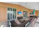 Expansive screened lanai featuring comfortable wicker seating, outdoor dining area, and a flatscreen television at 16137 Alcira Cir, Punta Gorda, FL 33955