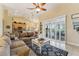 Bright living room features large sectional couch, a coffee table, and a sunny view into the backyard and pool at 16137 Alcira Cir, Punta Gorda, FL 33955
