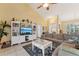 Comfortable living room with vaulted ceilings, a ceiling fan, a large sectional couch and a large entertainment center at 16137 Alcira Cir, Punta Gorda, FL 33955