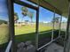 View of the backyard from the screened lanai showcasing the grassy lawn and exterior at 192 Garden Nw Ave, Port Charlotte, FL 33952