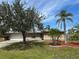 Charming single-story home with a well-maintained lawn, beautiful trees, and a two-car garage at 192 Garden Nw Ave, Port Charlotte, FL 33952
