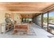 Indoor-outdoor living space featuring a wood ceiling, sliding doors, and modern patio furniture at 2191 Williamsburg Way, Englewood, FL 34224