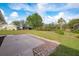 Expansive backyard with lush lawn, mature trees, and a serene view of the canal at 2545 Geneva Rd, Venice, FL 34293