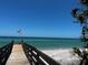 View of the beach and ocean from the dock with the American flag waving at 2545 Geneva Rd, Venice, FL 34293