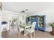 Open-concept dining area featuring wood-look floors, a dining table with seating, and a large blue cabinet at 2545 Geneva Rd, Venice, FL 34293